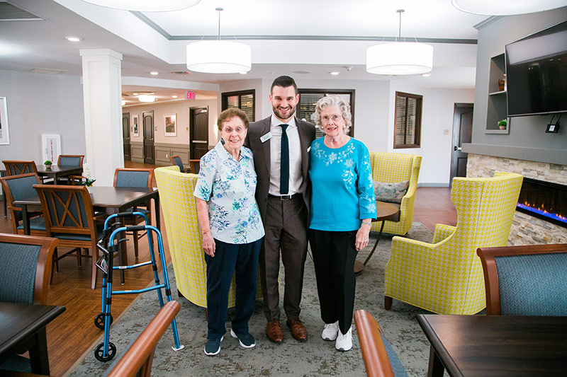 Bobby Nero standing with two residents