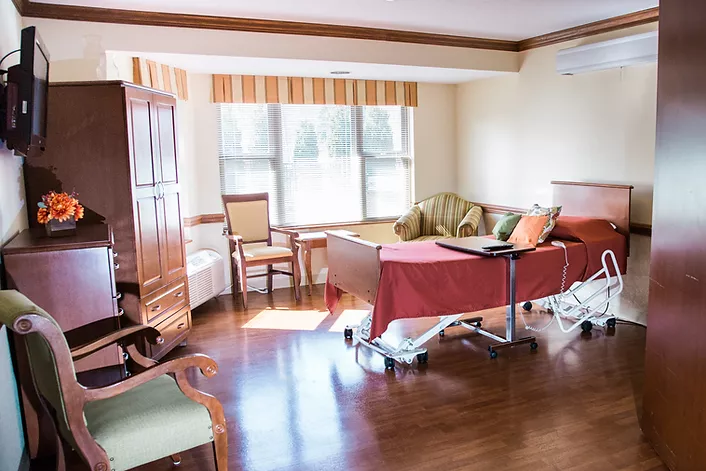 Resident room with burgundy comforter and hardwood floors