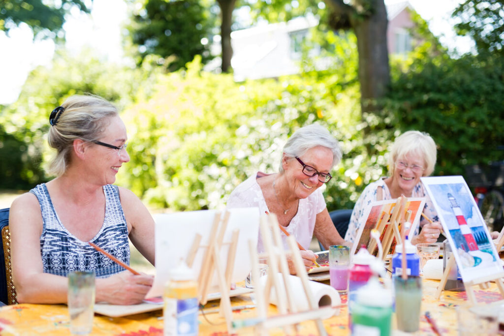 Happy senior women painting outside