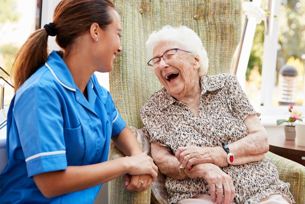 A senior woman shares a laugh with a nurse who supports her level of care at Brentwood.