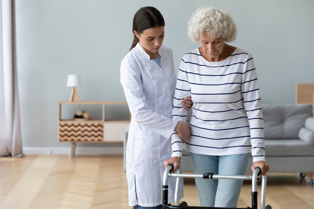 An on-site nurse practitioner helping guide the rehabilitation exercises for a senior citizen.